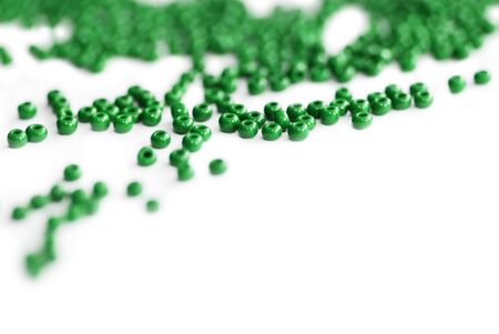 Green color seed beads scattered on a white close-up. Abstract backgroundの写真素材