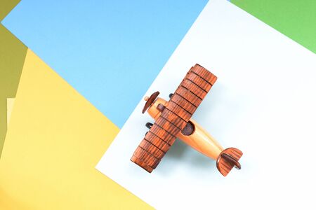 Wooden toy airplane on a colorful paper background close-upの写真素材