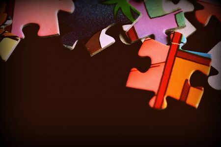 Puzzle pieces scattered on a dark background close up. Retro style tonedの写真素材