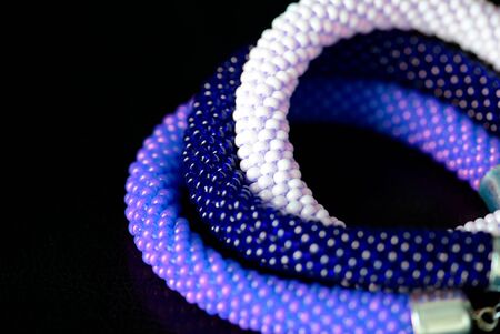 Three beaded bracelets on a dark background close up