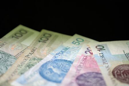 Polish zloty banknotes on a dark surface close-up. Money background green color toned