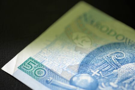 Fifty Polish zlotys on a dark background close up. Money background green color toned