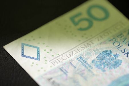 Fifty Polish zlotys on a dark background close up. Money background green color toned