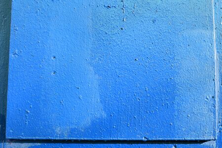 Old door blue color close-up lit by the bright sun. Abstract backgroundの写真素材