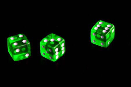 Green transparent dice on black background close-up. Gambling ?oncept