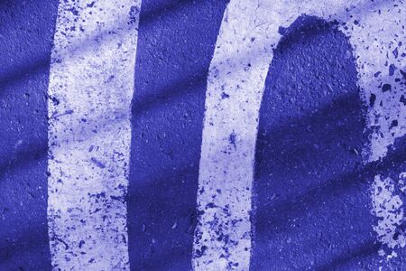 Asphalt surface with white paint and shadows close-up. Abstract background blue color tonedの写真素材