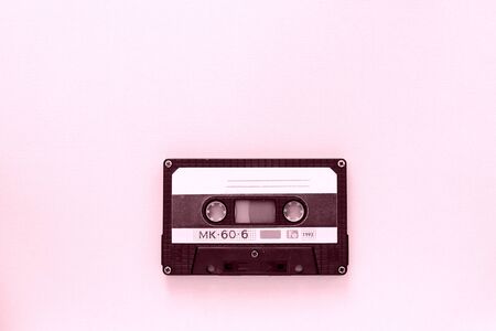 Old audio tape cassette close-up. Old technology concept. Pink color tonedの写真素材