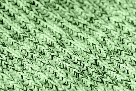 Knitted woolen texture close up. Textile background green color toned