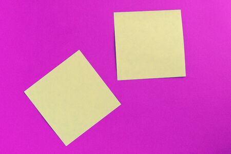 Two square sticker notes on a bright pink background close up