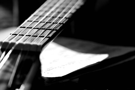 A fragment of an acoustic guitar lit by the sun. Black and whiteの写真素材