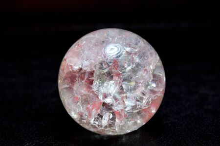 Glowing crystal ball with cracks inside on a dark background. The process of predicting the future