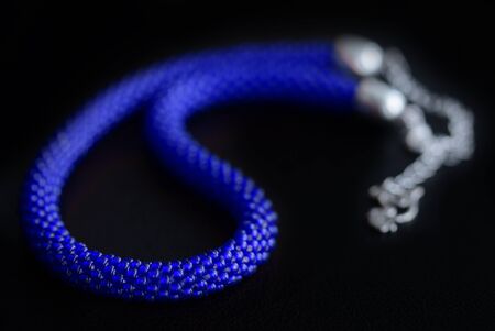 Bead crochet necklace blue color a dark surfce close up. Fashion backgroundの写真素材