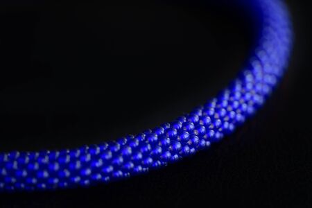 Bead crochet necklace blue color a dark surfce close up. Fashion background
