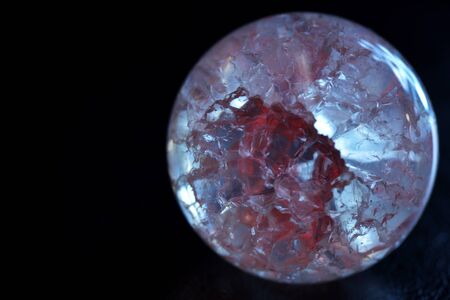 Glowing crystal ball with cracks inside on a dark background. The process of predicting the futureの写真素材