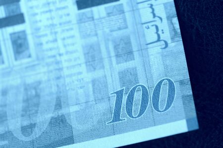 One hundred shekels banknote on a dark background close-up. Money background blue color tonedの写真素材