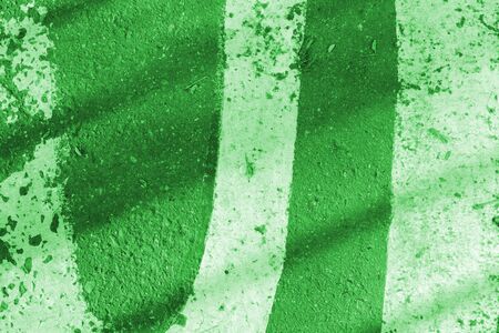 Asphalt surface with white paint and shadow. Abstract background green color tonedの写真素材