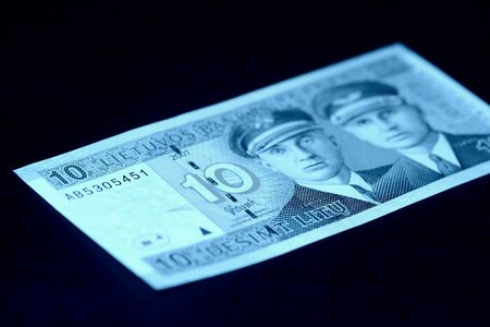 Outdated Lithuanian banknote on a dark surface. Ten litas close-up. Money background blue color tonedの写真素材