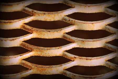Old rusty iron grid illuminated by the sun close up. Abstract background retro style tonedの写真素材