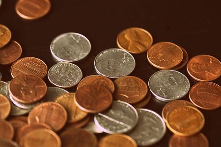 American cents coins are scattered on a black wooden surface. Money backgroundの写真素材