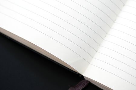 Open blank notebook with lined pages on a dark background close-up. Educational or business conceptの写真素材