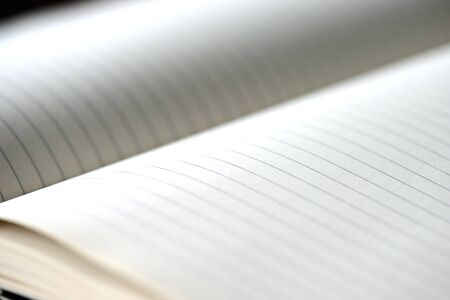 Open blank notebook with lined pages on a dark background close-up. Educational or business conceptの写真素材