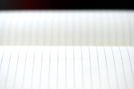 Open blank notebook with lined pages on a dark background close-up. Educational or business conceptの写真素材