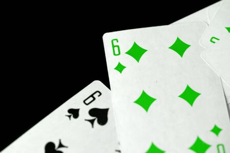 Playing cards unusual green color scattered on a black surface close-up. Gambling backgroundの写真素材