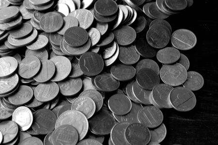 American cents on an old black wooden surface close-up. Monochrome money backgroundの写真素材