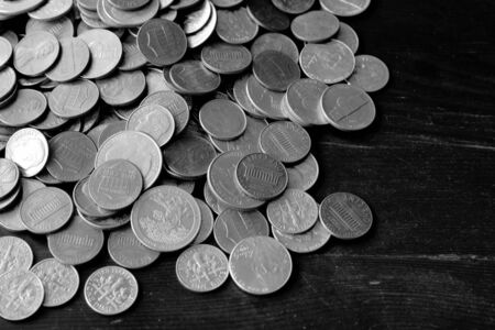 American cents on an old black wooden surface close-up. Monochrome money backgroundの写真素材