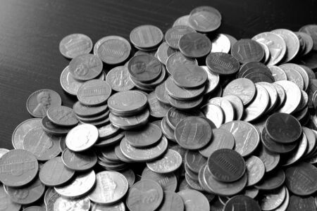 American cents on an old black wooden surface close-up. Monochrome money backgroundの写真素材