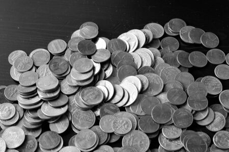 American cents on an old black wooden surface close-up. Monochrome money backgroundの写真素材