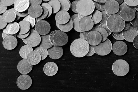 American cents on an old black wooden surface close-up. Monochrome money backgroundの写真素材
