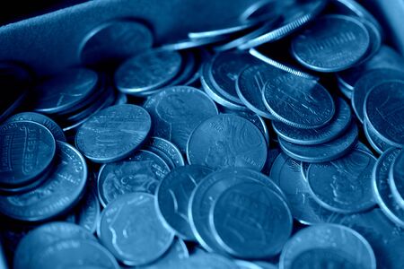 Paper box with a bunch of American cents close up. Money background blue color tonedの写真素材