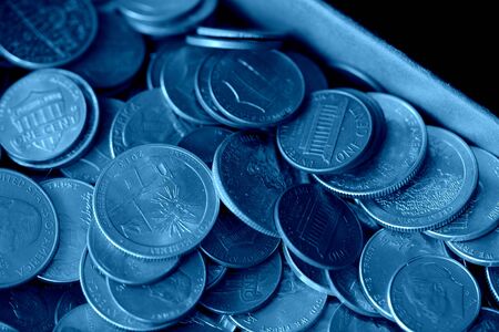 Paper box with a bunch of American cents close up. Money background blue color tonedの写真素材