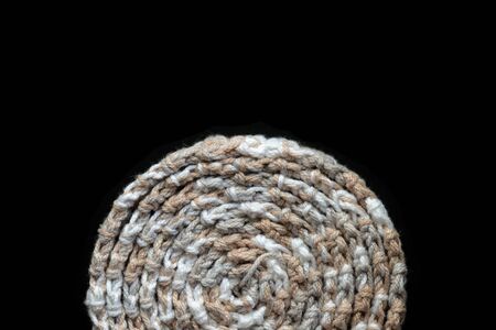 Crochet tape melange yarn brown and beige color on a black background close-up. Top view. Hand-made conceptの写真素材
