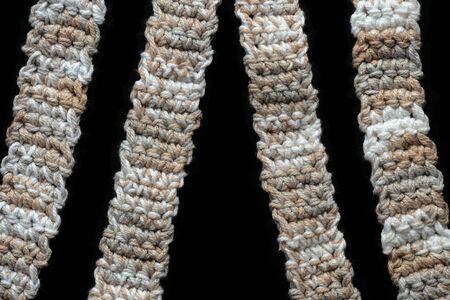 Melange yarn crocheted tape on a black background close up. Handmade concept. Top viewの写真素材
