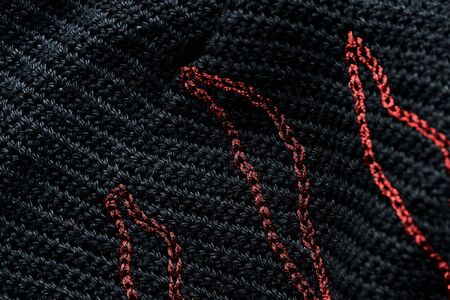 Close-up of a black crocheted bag with embroidery red thread. Hand made concept. Top viewの写真素材