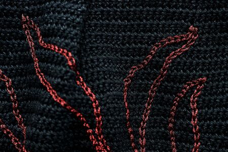 Close-up of a black crocheted bag with embroidery red thread. Hand made concept. Top viewの写真素材