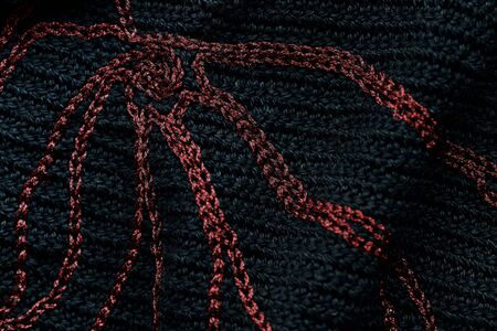 Close-up of a black crocheted bag with embroidery red thread. Hand made concept. Top viewの写真素材
