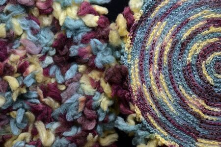 Two round crocheted fragments of fluffy multi-colored yarn close-up. Top view. Handmade conceptの写真素材