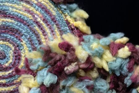 Two round crocheted fragments of fluffy multi-colored yarn close-up. Top view. Handmade conceptの写真素材
