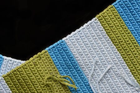 Crocheted fabric from multi-colored yarn close-up, top view. Abstract background. Hand made conceptの写真素材
