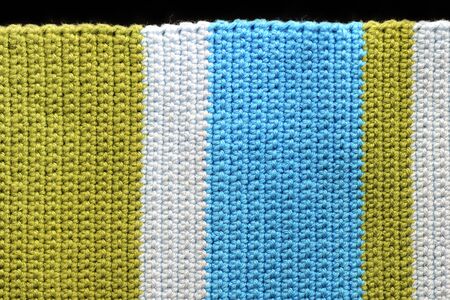 Crocheted fabric from multi-colored yarn close-up, top view. Abstract background. Hand made conceptの写真素材