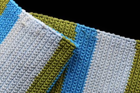 Crocheted fabric from multi-colored yarn close-up, top view. Abstract background. Hand made conceptの写真素材