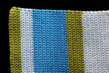 Crocheted fabric from multi-colored yarn close-up, top view. Abstract background. Hand made conceptの写真素材