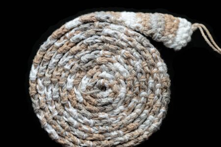 Crochet tape melange yarn rolled up on a black background close up. Top view. Handmade conceptの写真素材