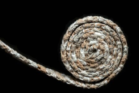 Crochet tape melange yarn rolled up on a black background close up. Top view. Handmade conceptの写真素材