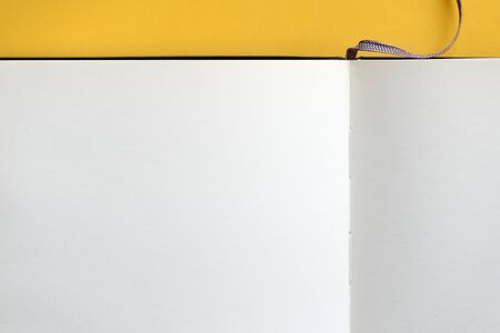 Top view of open blank notebook on yellow background close-up. The concept of education, business, planning. Flat layの写真素材