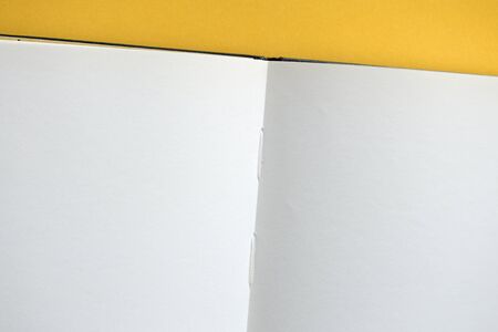 Top view of open blank notebook on yellow background close-up. The concept of education, business, planning. Flat layの写真素材