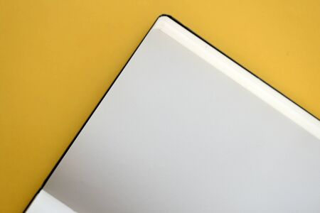 Top view of open blank notebook on yellow background close-up. The concept of education, business, planning. Flat layの写真素材